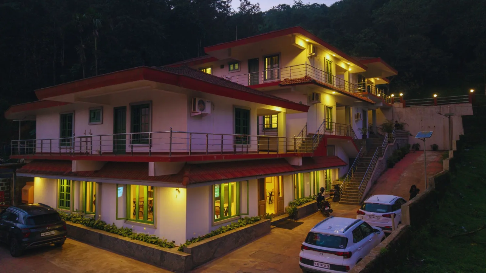 The front of Hasu Stay at dusk, its balconies and rooms lit across three terraced floors